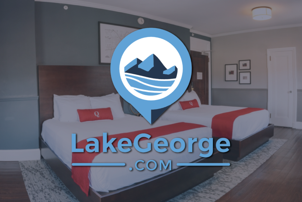 LakeGeorge.com logo overlay on a hotel room at The Queensbury Hotel
